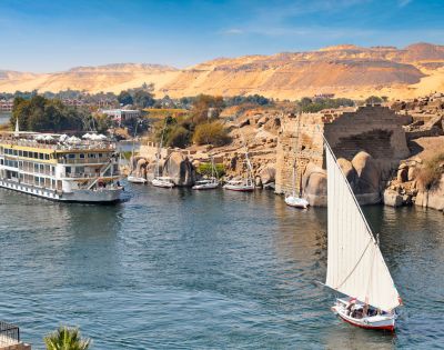 The Nile River flowing through Egypt, surrounded by lush greenery and ancient structures along its banks.