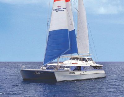 A catamaran with colorful blue, red, and white sails branded 