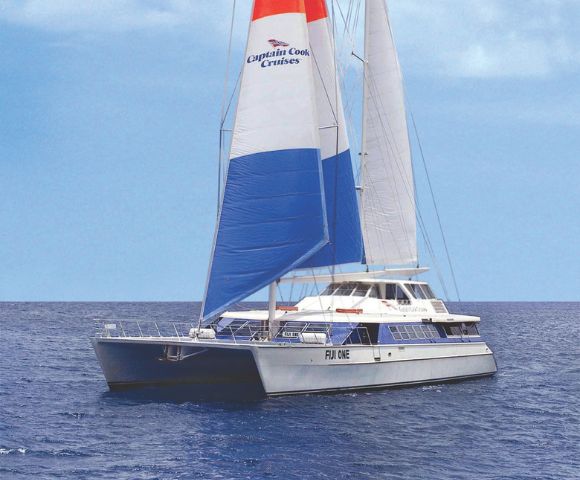 A catamaran with colorful blue, red, and white sails branded 