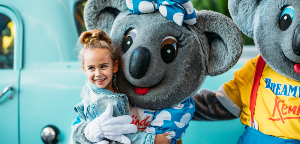 Dreamworld on the Gold coast captures a young girl embraces a koala bear, capturing a heartwarming interaction between a child and the animal.