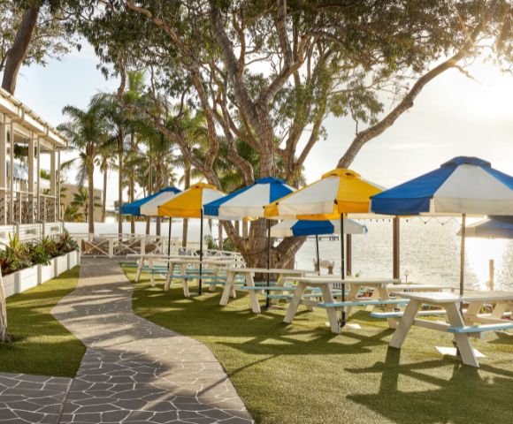 Beach umbrellas under the sun's soft lighting and serene lush greeneries.