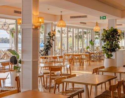 Restaurant's dining exterior featuring chandeliers and dim yellow lights and display plants.