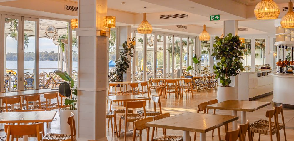 Restaurant's dining exterior featuring chandeliers and dim yellow lights and display plants.