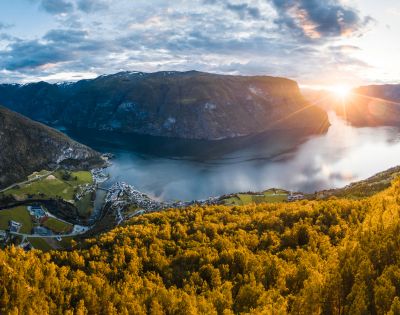 Breathtaking fjord surrounded by mountains at sunset, bathed in golden light.