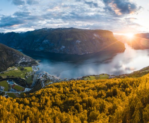 Breathtaking fjord surrounded by mountains at sunset, bathed in golden light.
