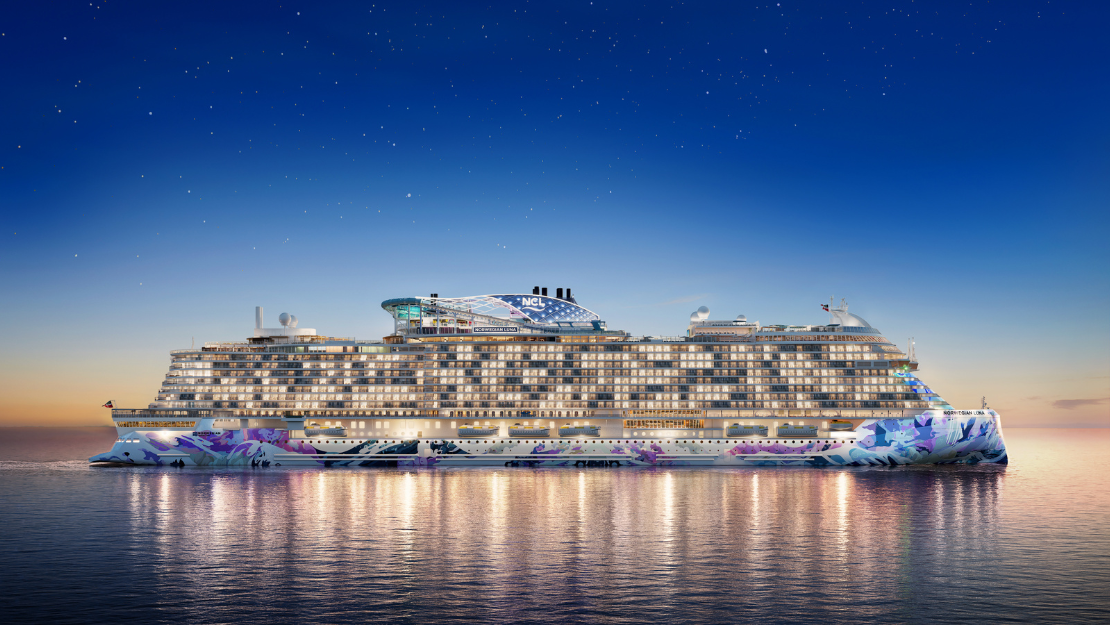 A colorful cruise ship floats on calm waters at sunset, featuring vibrant designs and illuminated windows against a twilight sky.