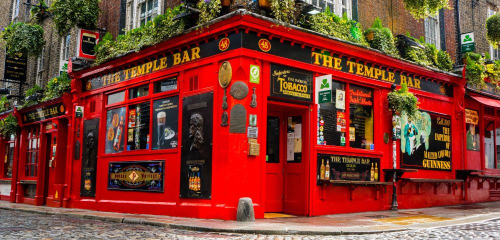The Temple Bar, Ireland – A lively red-painted pub on a cobblestone street in Dublin, known for its iconic exterior and cultural charm.