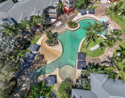 Aerial view of the resort’s pool area surrounded by tropical plants and winding pathways.