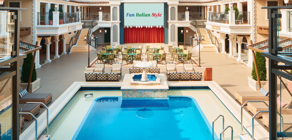 Elegant indoor space featuring an inviting pool, seating area, and a large screen displaying 