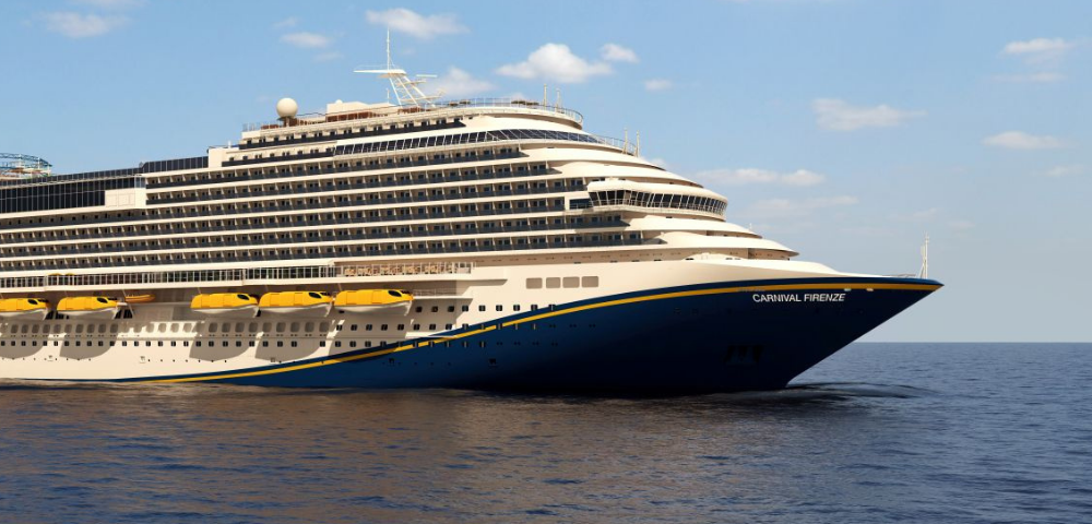 A large cruise ship, Carnival Firenze, sails on calm waters under a blue sky, showcasing its elegant design and yellow lifeboats.