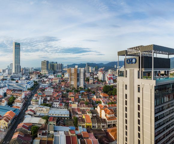 Aerial view of a cityscape with tall buildings under a clear blue sky.