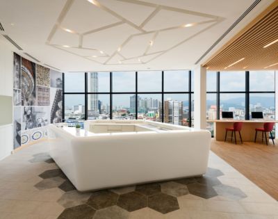 Spacious hotel room featuring large windows, modern decor, and a cozy seating area.