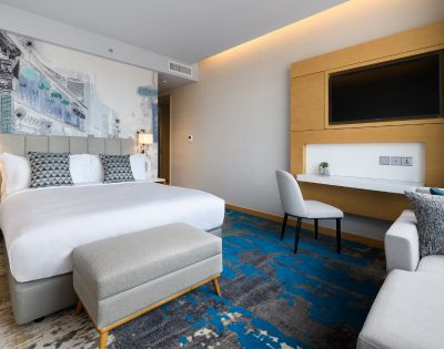 Hotel room with two beds, large windows, and contemporary furnishings.