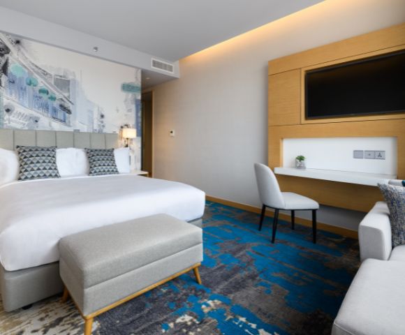 Hotel room with two beds, large windows, and contemporary furnishings.