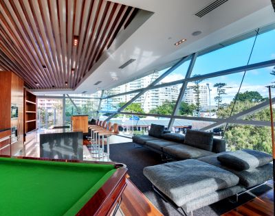 Entertainment room with a pool table and seating area, large windows offering an ocean view.