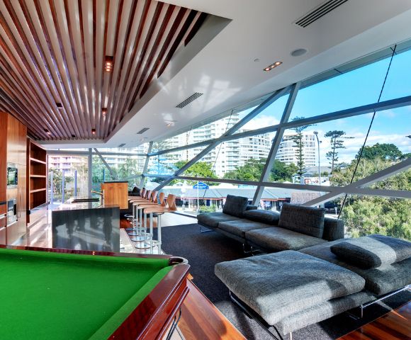 Entertainment room with a pool table and seating area, large windows offering an ocean view.