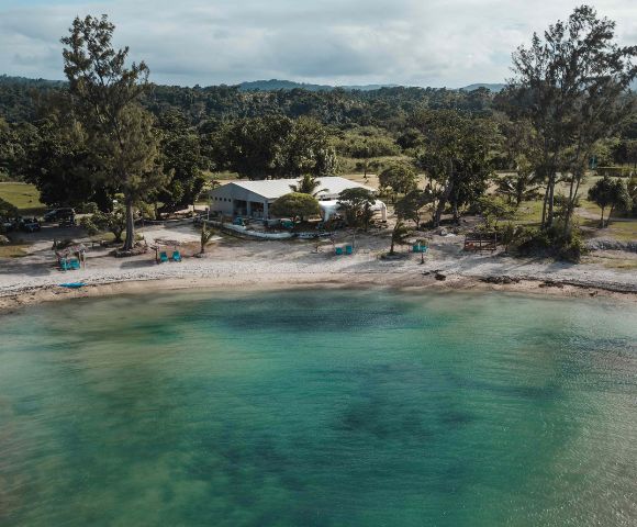 Scenic coastal view with clear blue water and lush greenery, showcasing the natural beauty of the resort.
