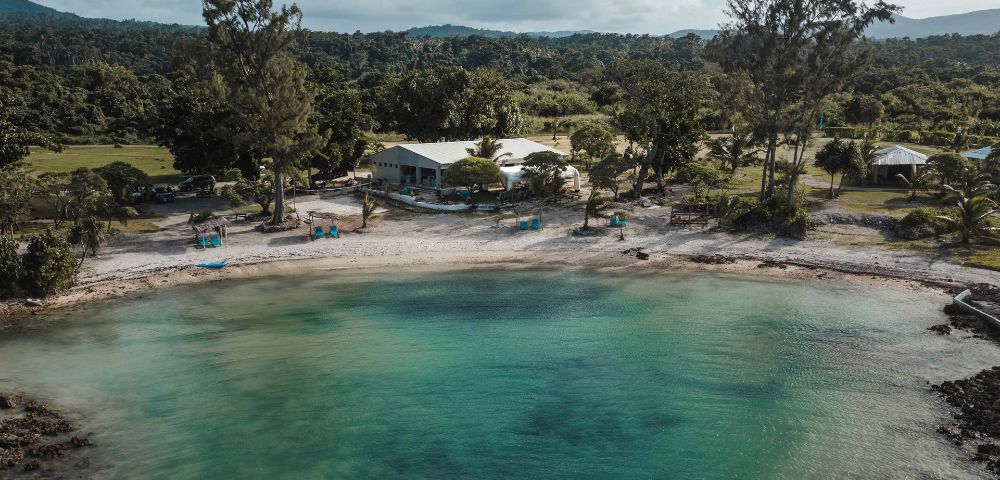 Scenic coastal view with clear blue water and lush greenery, showcasing the natural beauty of the resort.