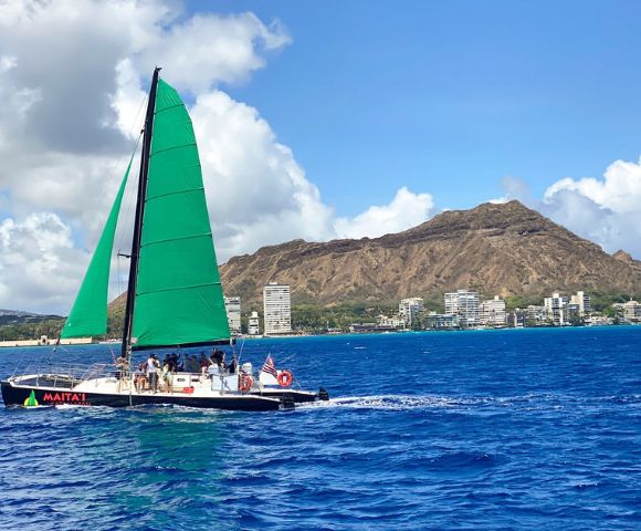 Green-sailed sailboat named 