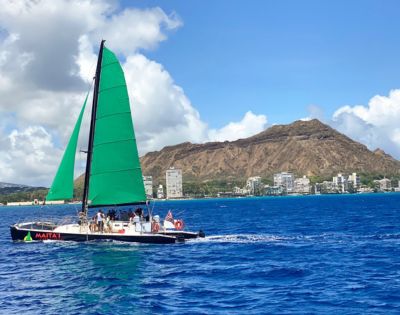 Green-sailed sailboat named 