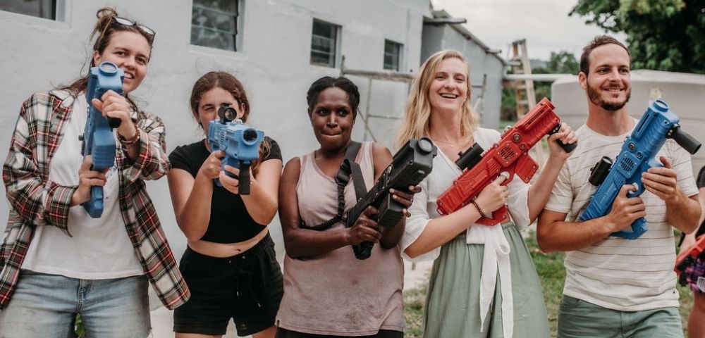 Group photo taken outside a building labeled “Le Life Resort” with multiple individuals posing.