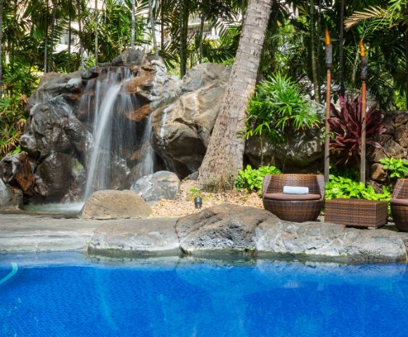 Close-up of water cascading over rocks in a garden waterfall feature.