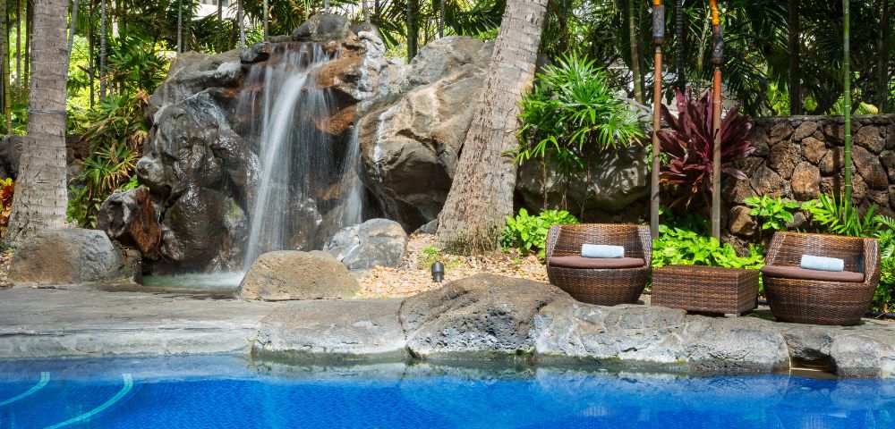 Close-up of water cascading over rocks in a garden waterfall feature.