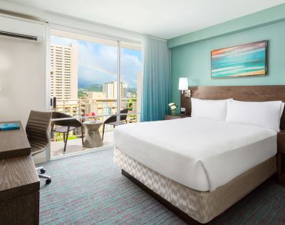 Bedroom with a large bed, bedside tables, lamps, and artwork on the wall.