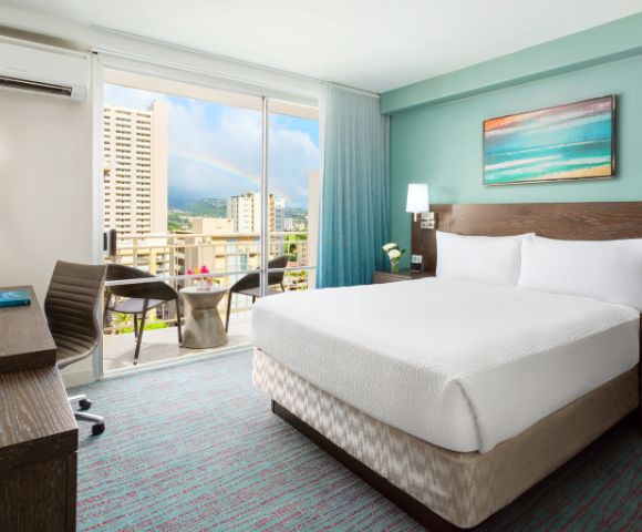 Bedroom with a large bed, bedside tables, lamps, and artwork on the wall.