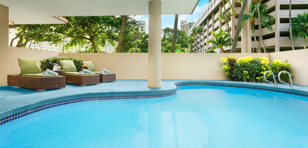 Alternate view of the swimming pool area with surrounding greenery.