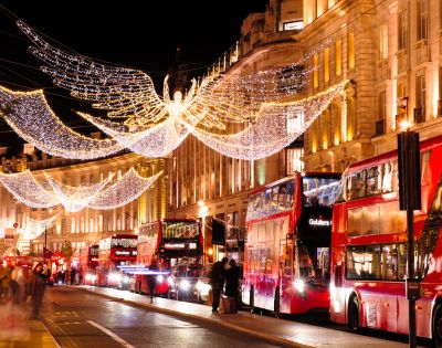 A lively London street sparkles with holiday lights and seasonal decorations.