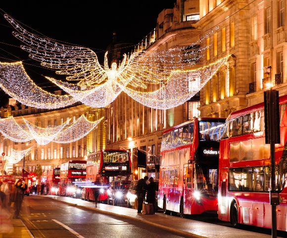 A lively London street sparkles with holiday lights and seasonal decorations.
