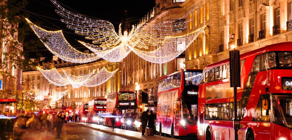 A lively London street sparkles with holiday lights and seasonal decorations.
