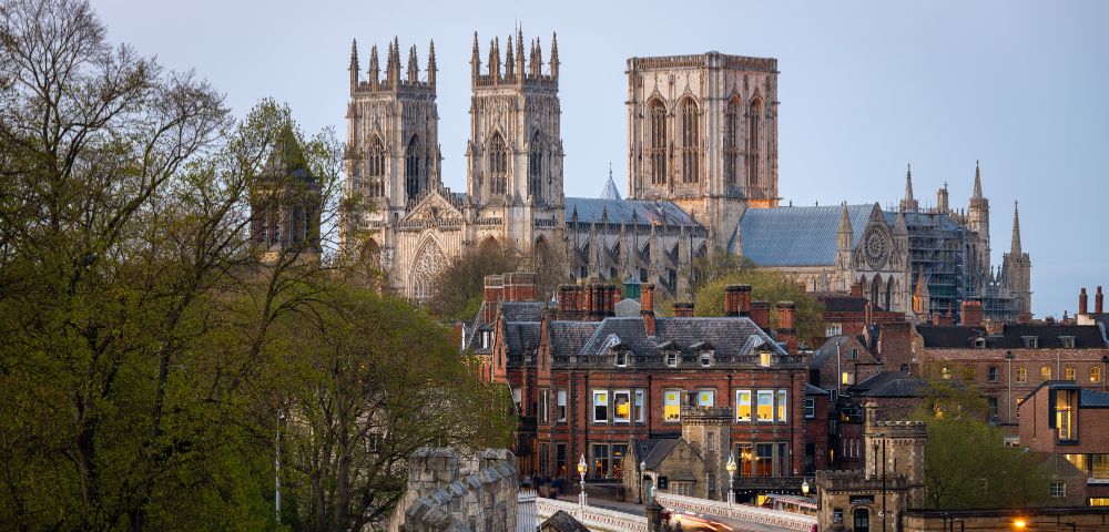 A scenic view of York Minster in England, showcasing its towering Gothic architecture above the historic city buildings.