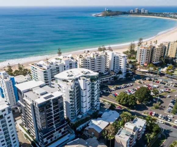 Aerial view of a coastal area showing high-rise buildings, beach, and ocean from a different angle.