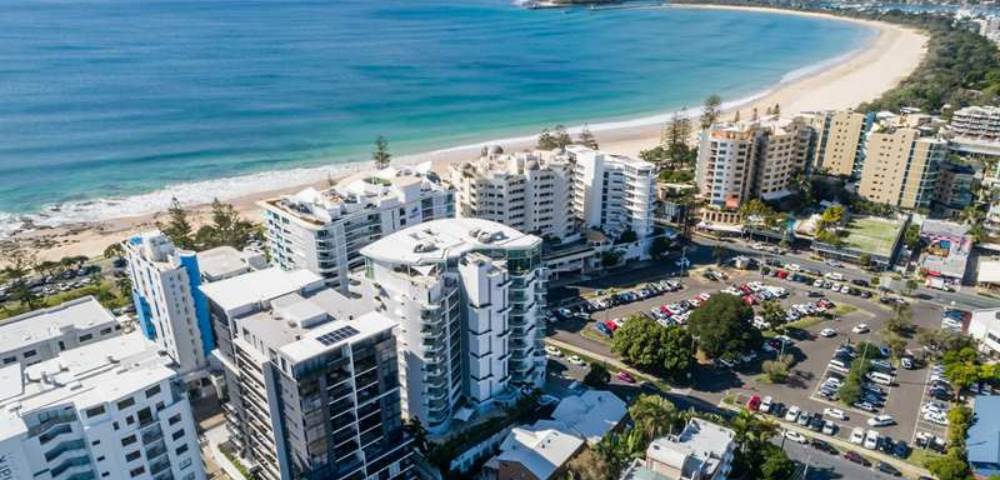 Aerial view of a coastal area showing high-rise buildings, beach, and ocean from a different angle.