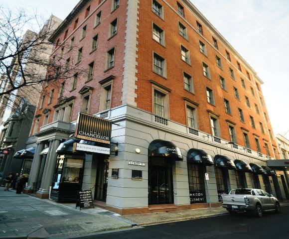 Exterior of a multi-story brick building with arched windows on the ground floor and several floors above.