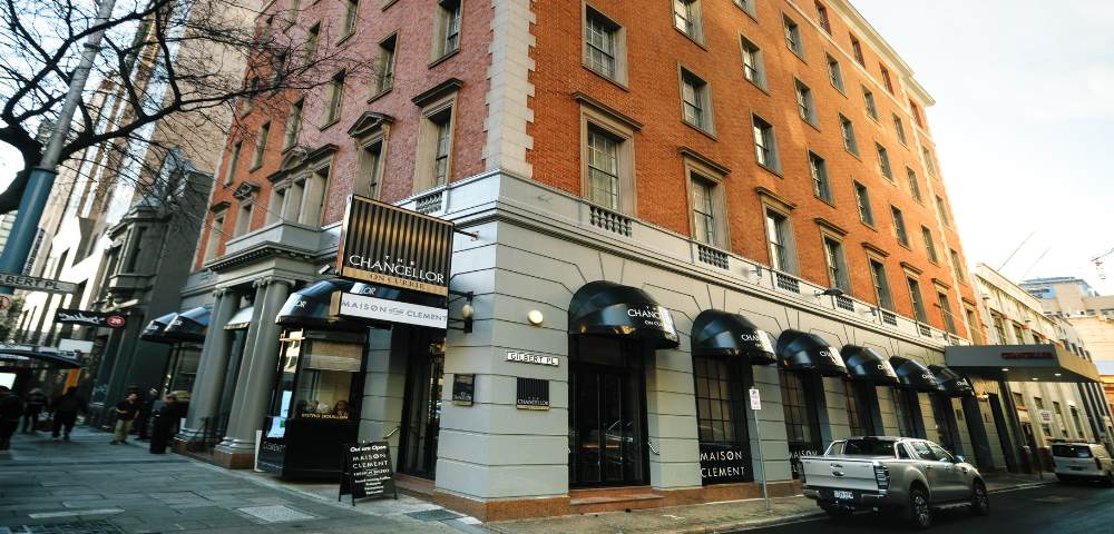 Exterior of a multi-story brick building with arched windows on the ground floor and several floors above.