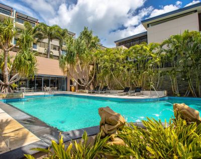 Smaller pool nestled among tropical plants within resort grounds.