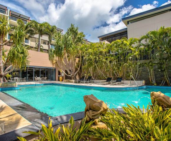Smaller pool nestled among tropical plants within resort grounds.