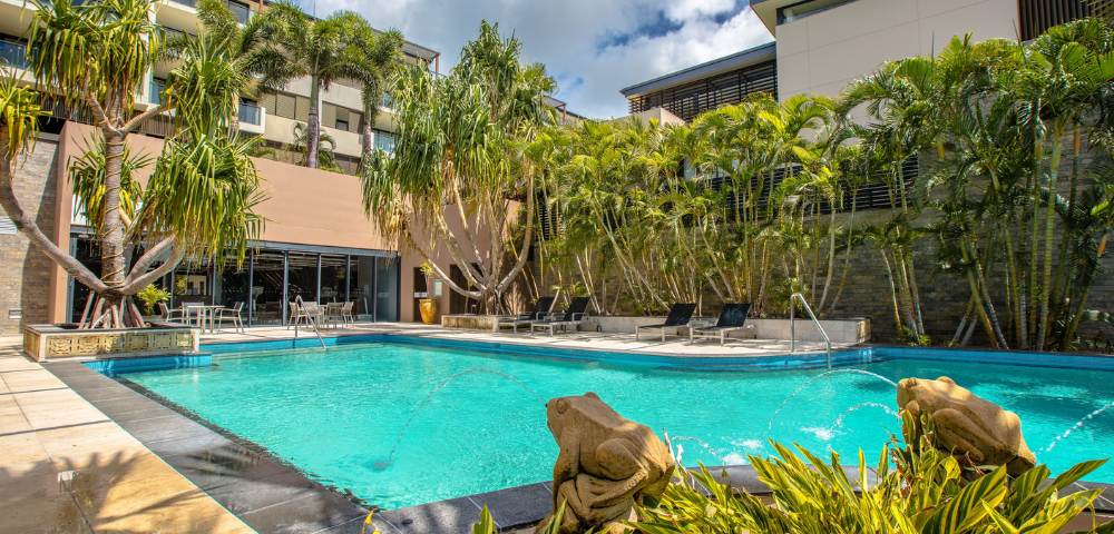 Smaller pool nestled among tropical plants within resort grounds.