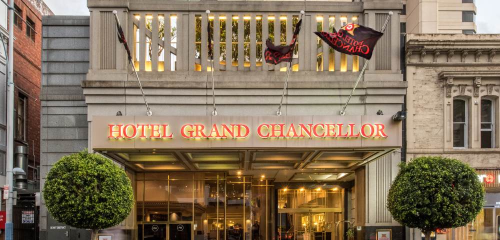 Elegant street-facing exterior of Hotel Grand Chancellor Adelaide with large windows and decorative architectural elements.