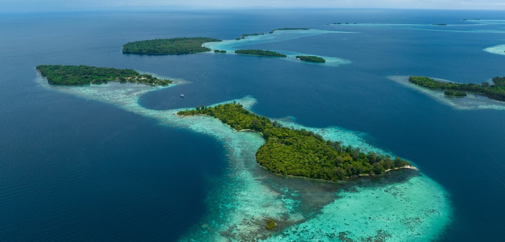 Aerial view of lush, green islands surrounded by turquoise waters in a calm sea.