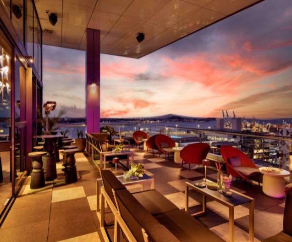 Rooftop bar or restaurant with outdoor seating and sunset views.