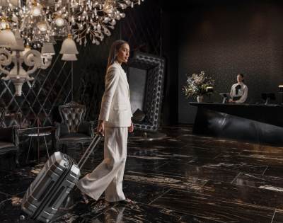 Elegant hotel room featuring a chandelier, dark-toned decor, and plush furnishings