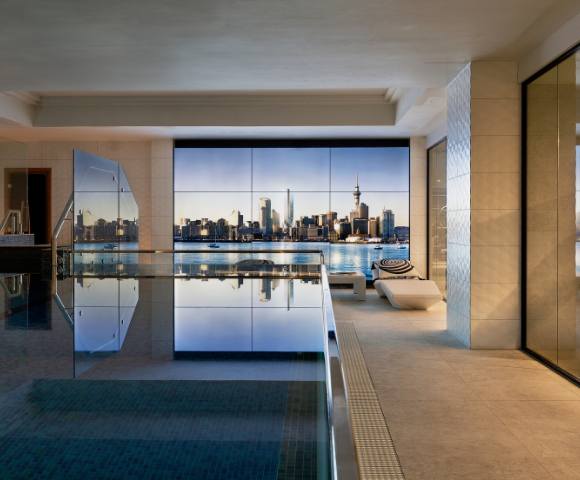 Spacious indoor swimming pool area with floor-to-ceiling windows offering outdoor views.
