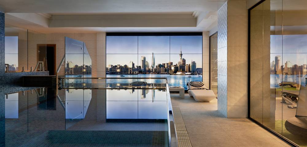 Spacious indoor swimming pool area with floor-to-ceiling windows offering outdoor views.