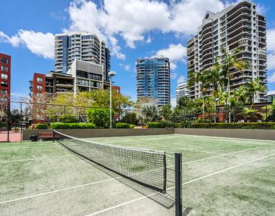 Full-sized tennis court within The Docks residential amenities.