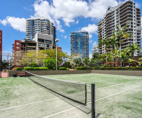 Full-sized tennis court within The Docks residential amenities.
