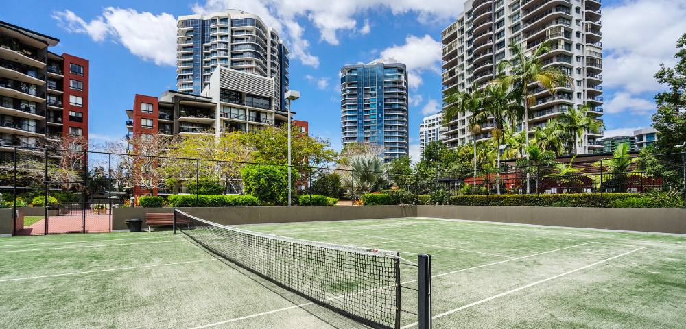 Full-sized tennis court within The Docks residential amenities.